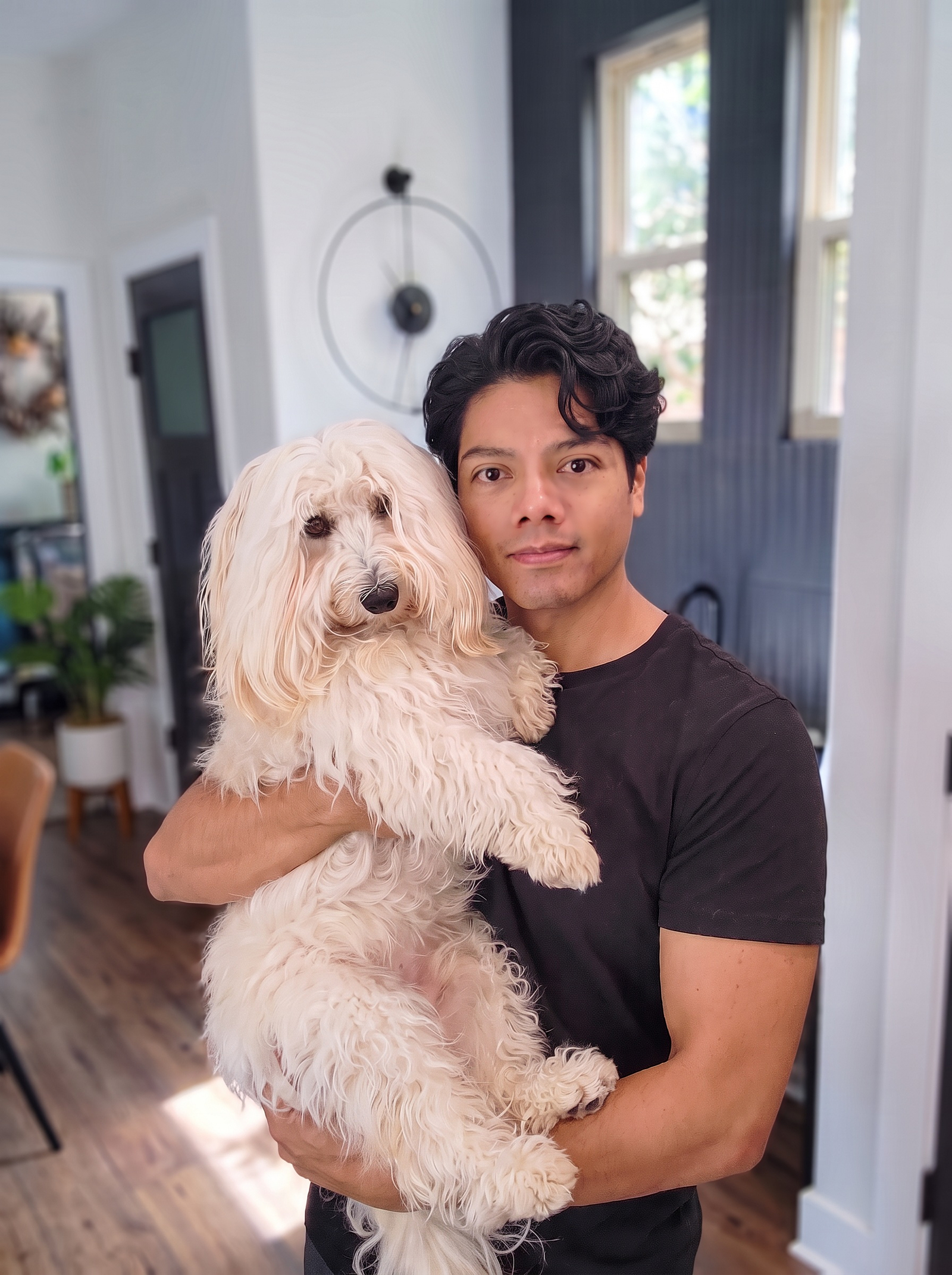 David, co-owner of Lares Petsitting, holding a fluffy white dog